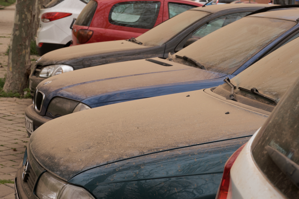 Red saharan dust settled on row of cars