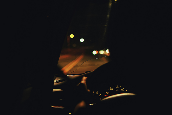 View of dashboard from the drivers perspective, looking at the dark road ahead at night